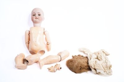 une petite poupée assise à côté d'une peluche