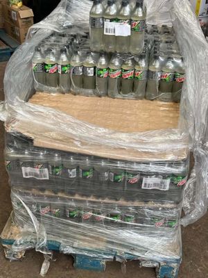 many bottles of soda sitting on a pallet in a warehouse