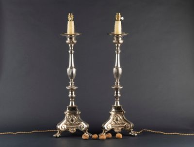 a pair of silver candles are sitting on a table