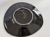 a black plate with a clock on it sitting on a table