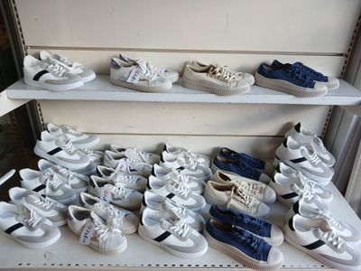 many pairs of shoes on a shelf in a store