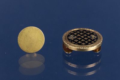 une photo représentant une montre en or et une pièce de monnaie sur un fond bleu