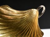 a close up of a gold vase on a table