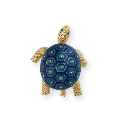 un gros plan d'une broche en forme de tortue sur fond blanc