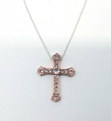un gros plan d'un collier orné d'une croix sur fond blanc