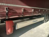 a red semi truck with a long bed on the back of it