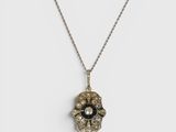 un gros plan d'un collier orné d'une fleur
