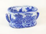 a blue and white bowl with handles on a white surface