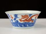 an orange and blue bowl with a dragon design on it