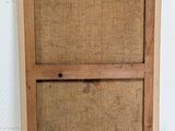 an old wooden picture frame with a piece of burlock on top of it