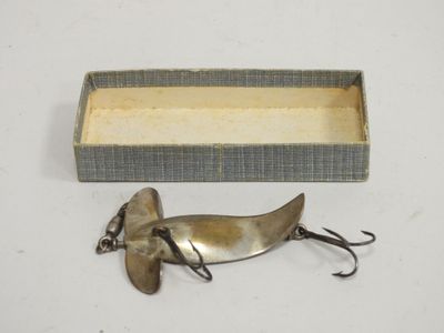 an old fishing lure in a box with a fishing hook