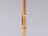 a close up of a wooden clarinet on a clear surface