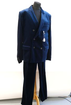 a suit on a mannequin stand in front of a window