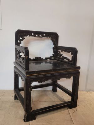 une chaise noire sur laquelle est posé un miroir