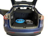 the back of a blue car with the trunk open and a hose in the trunk