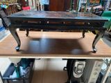 a wooden table with a black top on a shelf