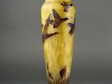yellow and brown vase with birds painted on it on a stand