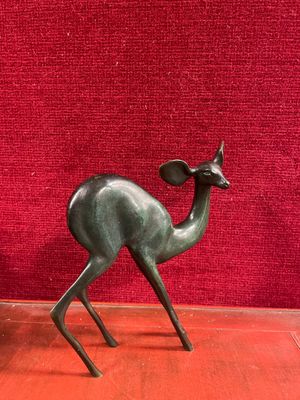 une statue représentant un cerf debout sur un socle rouge