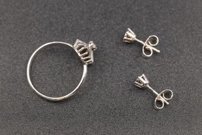 trois bijoux en argent posés sur une surface noire