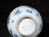 a blue and white vase sitting on a black surface