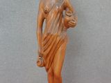 une statue représentant une femme tenant un bol sur la tête