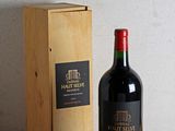 une bouteille de vin posée sur une table à côté d'une caisse en bois