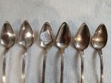 six cuillères sont alignées sur une table