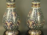 Trois vases sont posés sur une table devant un fond gris.
