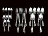de nombreuses cuillères en argent et cuillères-cuillères sur fond noir
