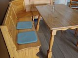 a wooden table and bench in a small room