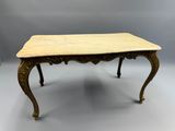 une petite table avec un plateau en marbre et des pieds ouvragés