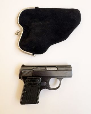 un pistolet et un sac à main posés sur une table