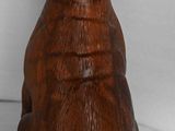 carved wooden dog figurine sitting on a white surface