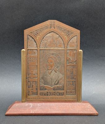 an old bronze plaque with a picture of a man holding a book