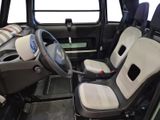 two seats in the back of a vehicle with a steering wheel