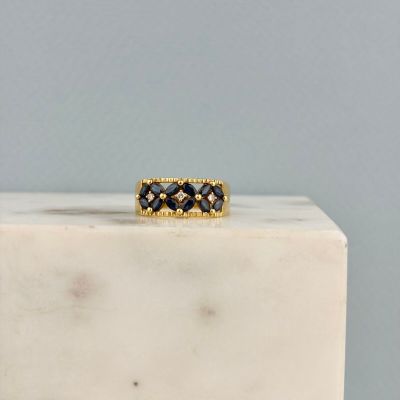 une photo d'une bague sertie d'un diamant noir posée sur un bloc de marbre