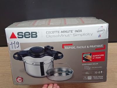 Quelqu'un tient une boîte contenant un autocuiseur sur une table.