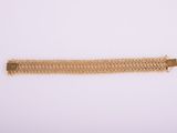 a gold bracelet on a white background