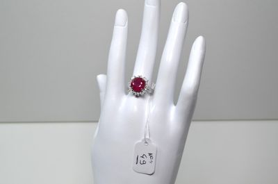 une main sur laquelle est passée une bague sertie d'une pierre rouge