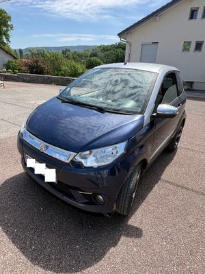 the small car is parked in the parking lot next to the house