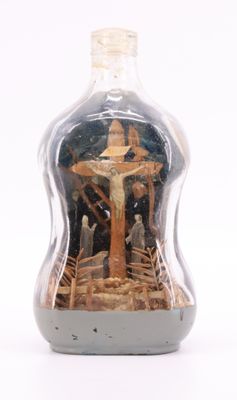 une bouteille à l'intérieur de laquelle se trouve une image de Jésus sur la croix