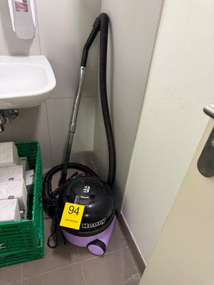 un aspirateur et un lavabo dans une petite salle de bains
