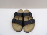 a close up of a pair of black sandals on a white surface