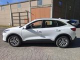 the white suv is parked in the parking lot near a building