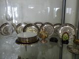 a glass display case with a lot of silver plates on it