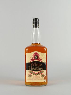 une bouteille de whisky « White Heather » posée sur une table