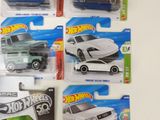 several hot wheels cars are lined up on a white surface