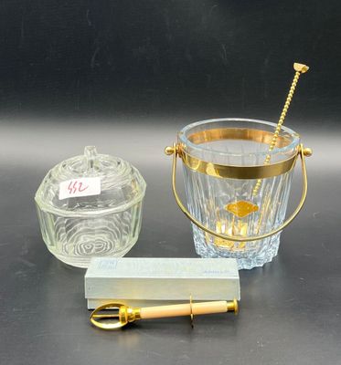 a glass ice bucket with a gold handle next to a glass ice bucket with a gold handle next to a glass ice bucket with a gold handle