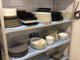 beaucoup d'assiettes et de casseroles sur les étagères de la cuisine