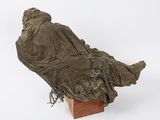 a statue of a woman sitting on top of a wooden block